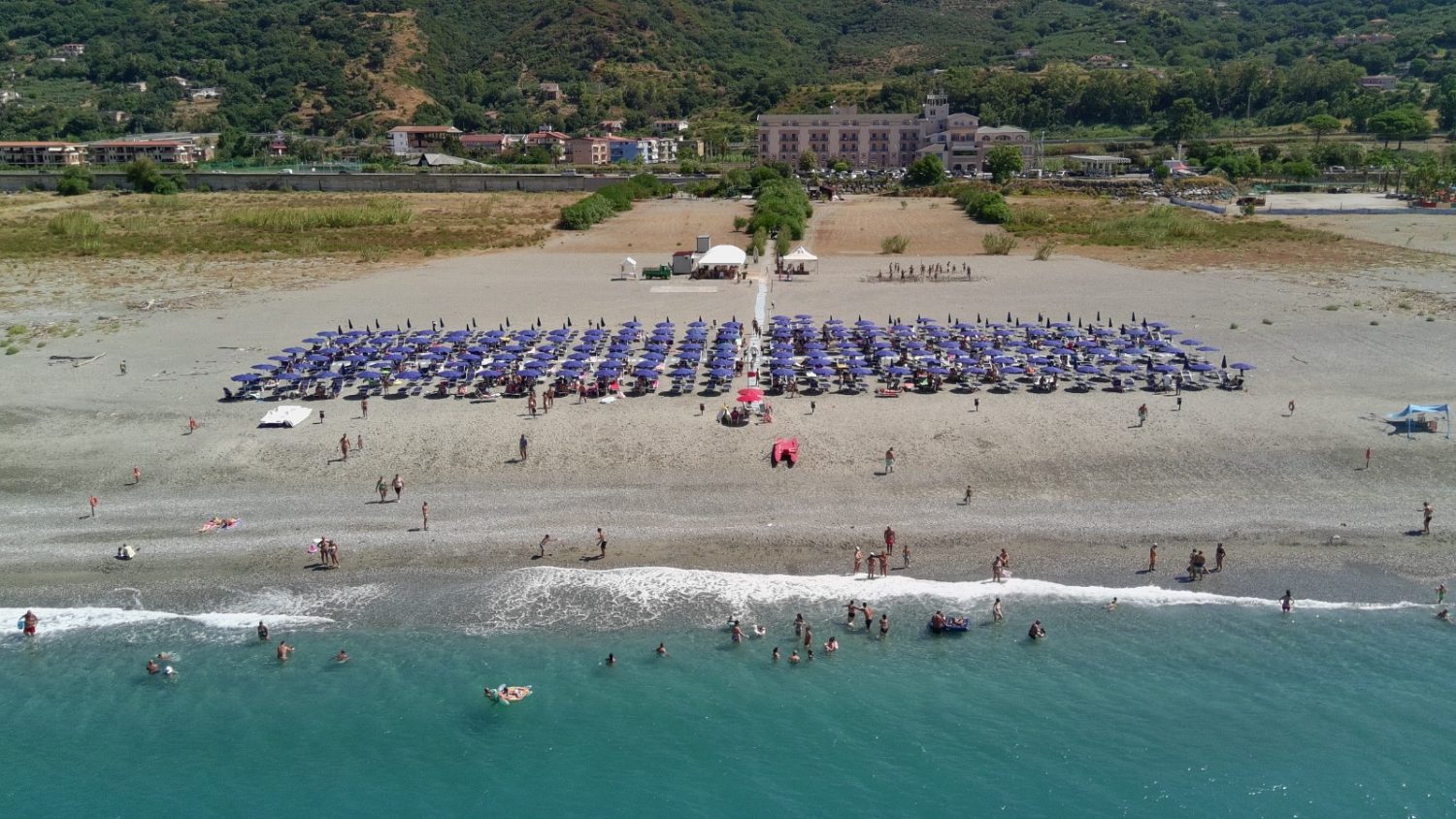La spiaggia attrezzata dell'Eurolido vista dal mare, con ombrelloni blu e la struttura sullo sfondo