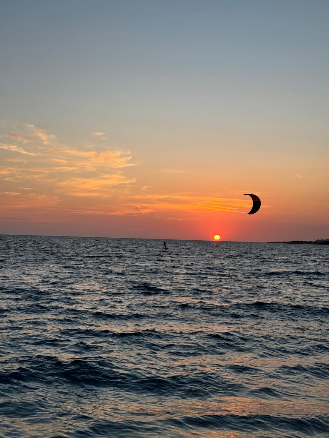 Kitesurfer in navigazione al tramonto