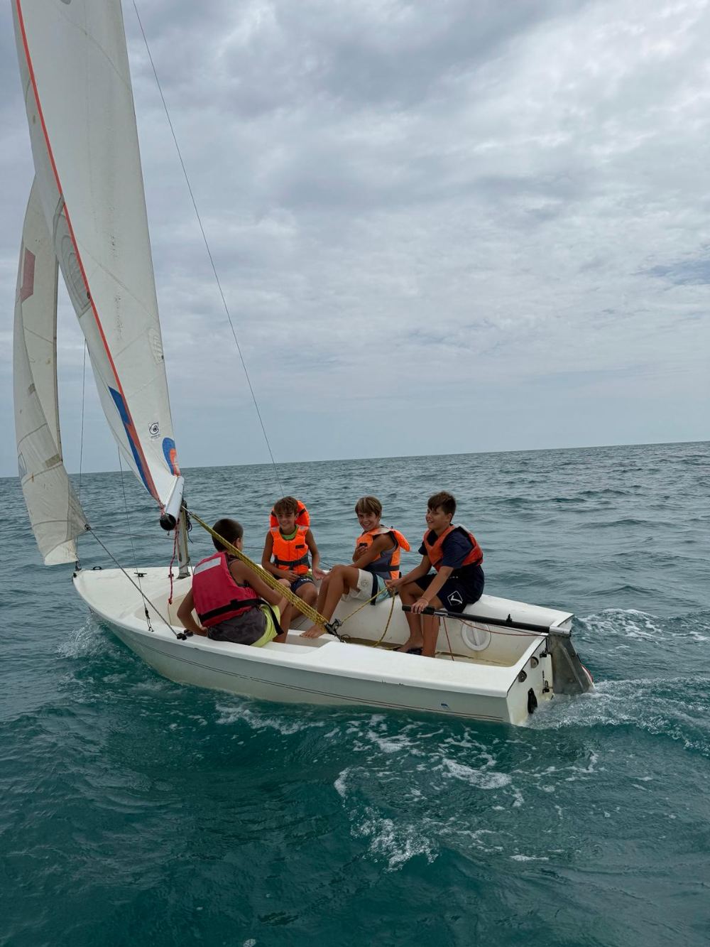 Equipaggio di ragazzi a bordo di una deriva in navigazione
